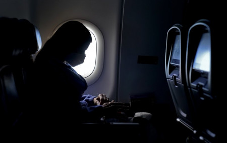 In this Wednesday, Feb. 3, 2021, file photo, a passenger wears a face mask she travels after take off from Hartsfield-Jackson International Airport in Atlanta.