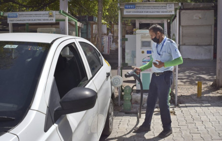 A driver of an electric car charges his vehicle at public charging station in New Delhi, India, Thursday, April 1, 2021.