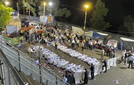 Israeli security officials and rescuers stand around the bodies of victims who died during a Lag Ba'Omer celebrations at Mt. Meron in northern Israel, Friday, April 30, 2021.