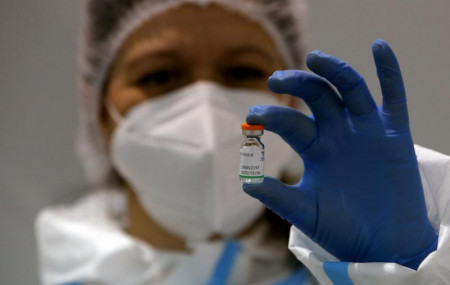 In this Tuesday, Jan. 19, 2021 file photo, a medical worker poses with a vial of the Sinopharm's COVID-19 vaccine in Belgrade, Serbia.