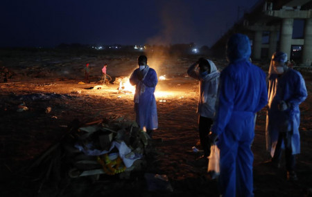 Family members pay last respect to their relative who died of COVID-19 before cremation by the River Ganges in Prayagraj, India, Saturday, May 8, 2021.