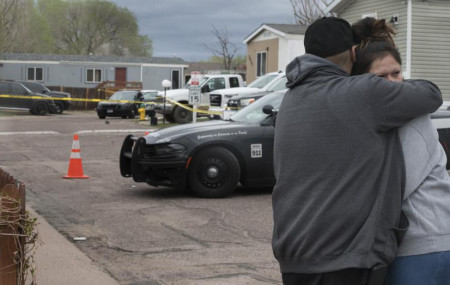 Family and friends of the victims who died in a shooting, comfort each down the street from the scene in Colorado Springs, Colorado, on Sunday, May 9, 2021.