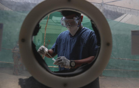 In this April 12, 2021, file photo, health worker collects nasal swab samples at a COVID-19 testing center in Hyderabad, India.