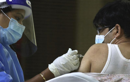 In this Feb. 8, 2021 file photo, a man receives his Sinopharm COVID-19 vaccine from a medical staffer at Guru Nanak Darbar temple in Dubai, United Arab Emirates.