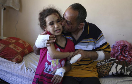 Suzy Ishkontana, 7, is kissed by her father Riad Ishkontana, 42, at Shifa Hospital in Gaza City, Tuesday, May 18, 2021.