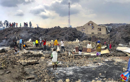 People gather on a stream of cold lava rock following the overnight eruption of Mount Nyiragongo in Goma, Congo, Sunday, May 23, 2021.