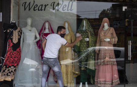 A Kashmiri shopkeeper cleans the display of his shop that was opened following a partial relaxation in the lockdown imposed to curb the spread of coronavirus in Srinagar, Indian controlled Ka