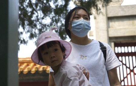 Mother of two, Yue Yan looks after one of her daughters at a park in Beijing on Thursday, May 20, 2021.