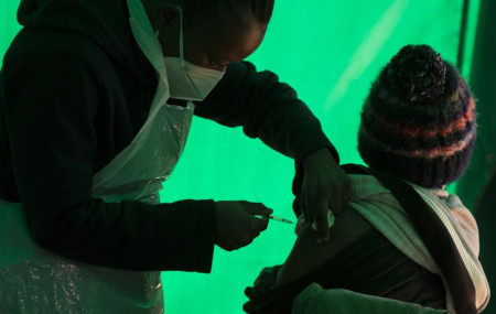 In this Thursday, June 3, 2021, file photo, an elderly patient receives a dose of the Pfizer COVID-19 vaccine at a clinic at Orange Farm, near Johannesburg.