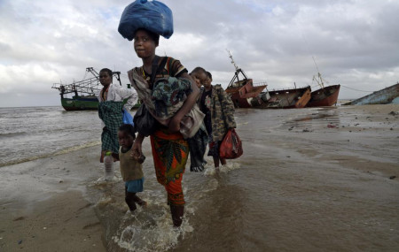 In this Saturday, March 23, 2019 file photo, displaced families arrive after being rescued by boat from a flooded area of Buzi district, 200 kilometers (120 miles) outside Beira, Mozambique.