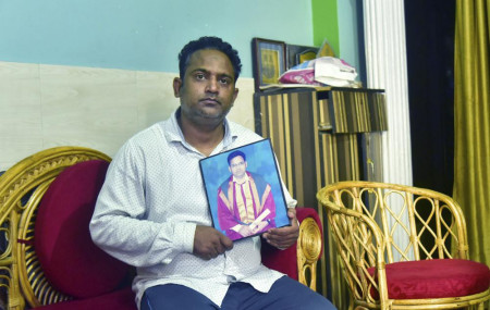 A relative holds a photograph of Dr. Jibraeil, assistant professor of history at Aligarh Muslim Uliversity, who died of COVID-19, in Aligarh, India, Saturday, June 12, 2021.