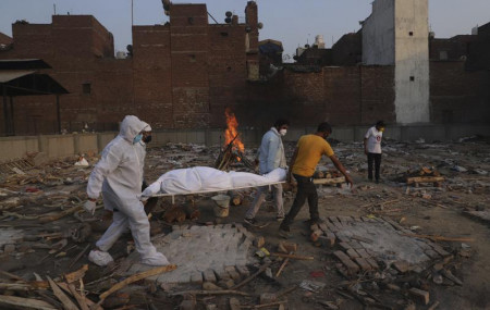 In this May 11, 2021, file photo, family members and volunteers carry the body of a COVID-19 victim for cremation in New Delhi, India.