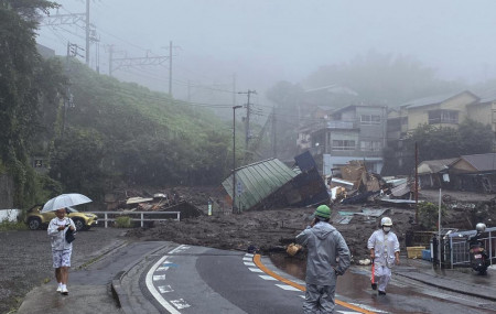 In this photo taken and provided by Satoru Watanabe, a road is covered by mud and debris following heavy rain in Atami city, Shizuoka prefecture, Saturday, July 3, 2021.