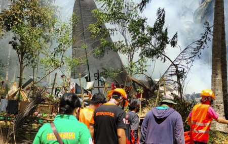 Rescuers search for bodies from the site where a Philippine military C-130 plane crashed in Patikul town, Sulu province, southern Philippines on Sunday, July 4, 2021.