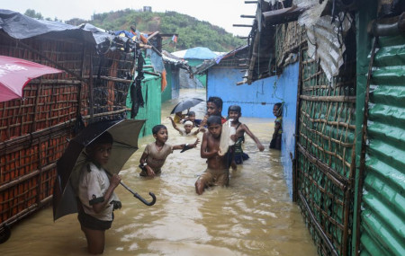 Rohingya refugee children play in flood waters at the Rohingya refugee camp in Kutupalong, Bangladesh, Wednesday, July 28, 2021.