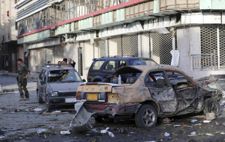 An Afghan national army soldier, left, stands guard near debris following an attack in Kabul, Afghanistan, Wednesday, Aug. 4, 2021.