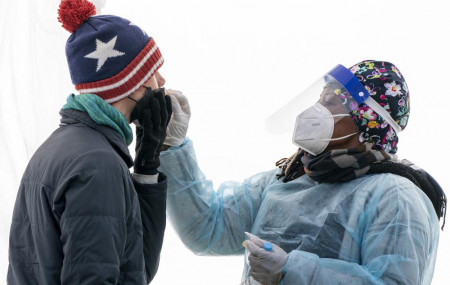 A man is swabbed for COVID-19 at a walk-up testing site at Farragut Square on Dec. 23, 2021, just blocks from the White House in Washington.