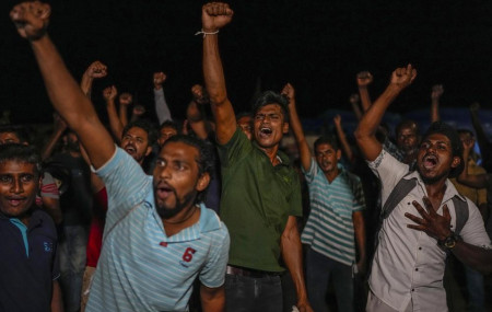 Sri Lankans celebrate as they react to early reports of President Gotabaya Rajapaksa's resignation in Colombo, Sri Lanka, Thursday, July 14, 2022. AP/RSS Photo