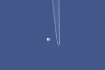 In this photo provided by Brian Branch, a large balloon drifts above the Kingstown, N.C. area, with an airplane and its contrail seen below it. AP/RSS Photo