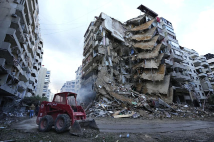 A Civil Defense worker uses a skid loader to remove the rubble in front of a destroyed building that was hit Sunday night in an Israeli airstrike in Dahiyeh, in the southern suburb of Beirut, Lebanon, Monday, Nov. 25, 2024. (AP Photo)