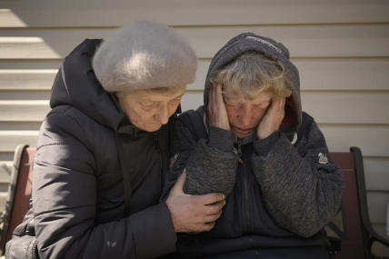 FILE - A neighbor comforts Natalia Vlasenko, whose husband, Pavlo Vlasenko, and grandson, Dmytro Chaplyhin, called Dima, were killed by Russian forces, as she cries in her garden in Bucha, Ukraine, Monday, April 4, 2022. AP/RSS Photo