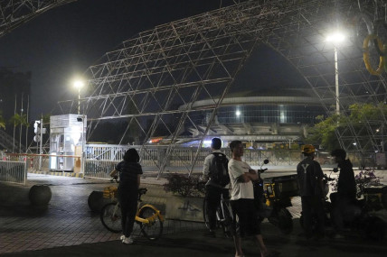 People gather near a sports center after a man rammed a car into people exercising at the center in Zhuhai, China Monday, Nov. 11, 2024. (AP)