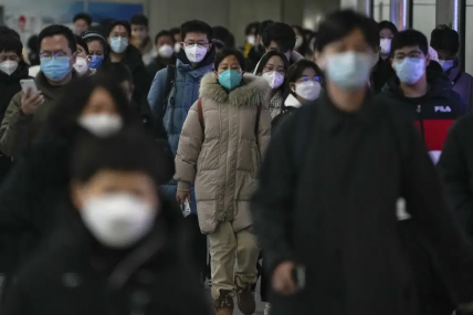FILE - Masked commuters walk through a walkway in between two subway stations as they head to work during the morning rush hour in Beijing, Tuesday, Dec. 20, 2022. AP/RSS Photo