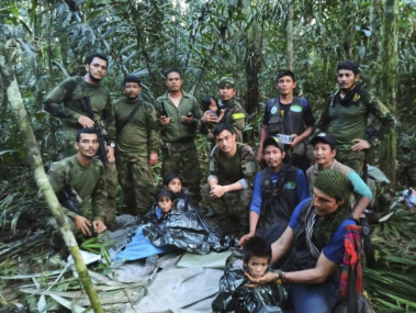 In this photo released by Colombia's Armed Forces Press Office, soldiers and Indigenous men pose for a photo with the four Indigenous children who were missing after a deadly plane crash, in the Solano jungle, Caqueta state, Colombia, Friday, June 9, 2023.  AP/RSS Photo