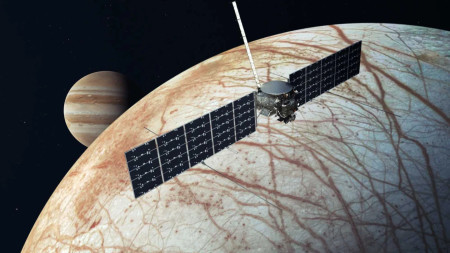 NASA illustration shows Europa Clipper over Europa with Jupiter at background.