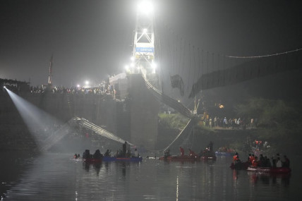 Rescuers on boats search in the Machchu river next to a cable suspension bridge that collapsed in Morbi town of western state Gujarat, India, Monday, Oct 31, 2022. (AP/RSS Photo)