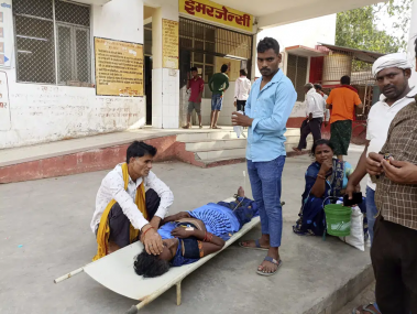 Relatives attend to a patient lying on a stretcher in the premises of a hospital in Ballia district, in northern Uttar Pradesh state, India, Sunday, June 18, 2023. AP/RSS Photo