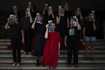 Relatives and supporters of Israeli hostages held by Hamas in Gaza hold photos of their loved ones during a performance calling for their return in Tel Aviv, Israel, Thursday, May 23, 2024. (AP Photo)