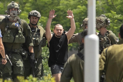Almog Meir Jan, 22, kidnapped from Israel in a Hamas-led attack on Oct. 7, 2023, raises his hands after arriving by helicopter to the Sheba Medical Center in Ramat Gan, Israel, Saturday, June 8, 2024. (AP Photo)