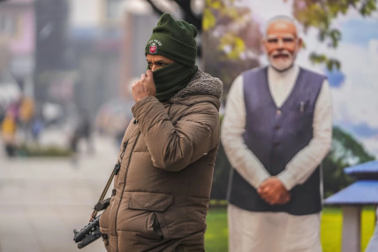 An Indian policeman stands guard near a cutout portrait of Indian Prime Minister Narendra Modi displayed at the main market in Srinagar, Indian controlled Kashmir, Monday, Dec. 11, 2023. (AP/RSS Photo)