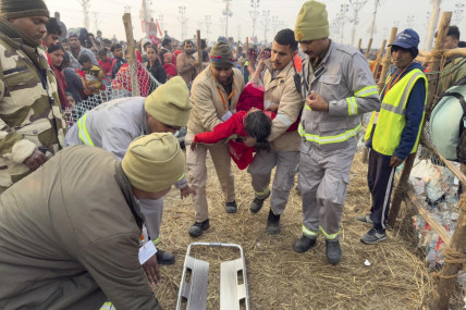 Security officers carry a woman out from the site of a stampede at the Sangam, the confluence of the Ganges, the Yamuna and the mythical Saraswati rivers, on “Mauni Amavasya” or new moon day during the Maha Kumbh festival, in Prayagraj, Uttar Pradesh, India, Wednesday, Jan. 29, 2025. (AP Photo)