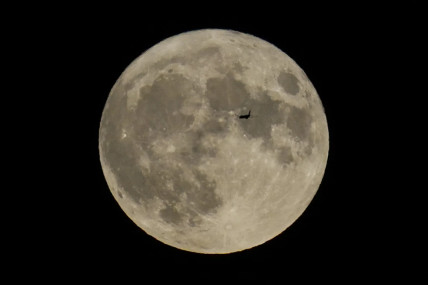 FILE - A plane passes in front of the moon, Aug. 30, 2023, in Chicago. Scientists have confirmed a cave on the moon, not far from where Neil Armstrong and Buzz Aldrin landed 55 years ago this week, and suspect there are hundreds more that could house future astronauts. AP/RSS Photo