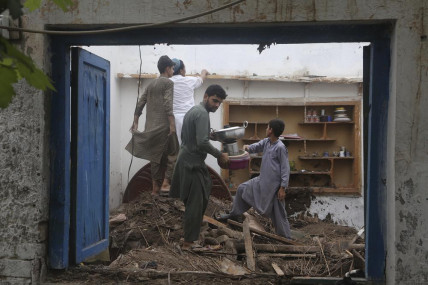 People salvage usable items from their house, after the roof collapsed due to heavy rains, in Peshawar, Pakistan, Thursday, July 28, 2022. The National Disaster Management Authority said Wednesday that 337 people died across the country in rain-related in