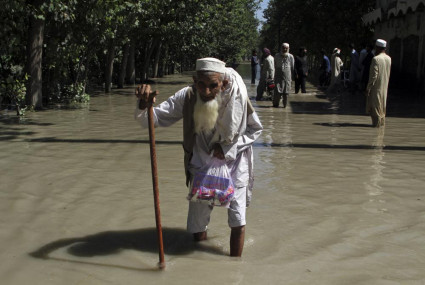 FILE - A displaced man wades through a flooded area after fleeing his flood-hit home, on the outskirts of Peshawar, Pakistan, Aug. 28, 2022.  AP/RSS Photo