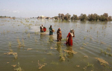 Pakistani women wade through floodwaters as they take refuge in Shikarpur district of Sindh Province, of Pakistan, Friday, Sep. 2, 2022. AP/RSS Photo