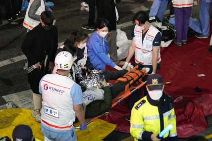Rescue workers carry injured people on the street near the scene in Seoul, South Korea, Sunday, Oct 30, 2022. (AP/RSS Photo)