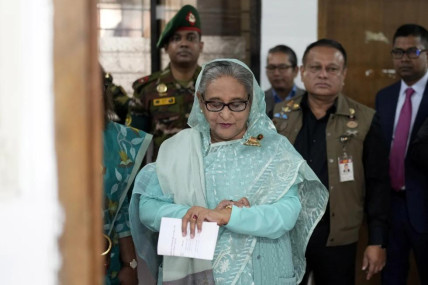 FILE- Bangladesh Prime Minister Sheikh Hasina checks her watch as she waits for the official opening time to cast her vote in Dhaka, Bangladesh, Jan. 7, 2024. (AP Photo)