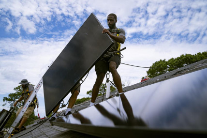 FILE - Employees of NY State Solar, a residential and commercial photovoltaic systems company, install an array of solar panels on a roof, Aug. 11, 2022, in the Long Island hamlet of Massapequa, New York. AP/RSS Photo