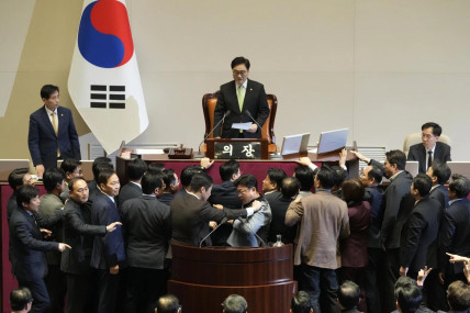 South Korea’s National Assembly Speaker Woo Won Shik, top, speaks as lawmakers of the ruling People Power Party protest during a plenary session for the impeachment motion against the country’s acting President Han Duck-soo at the National Assembly in Seoul, South Korea, Friday, Dec. 27, 2024. (AP Photo)