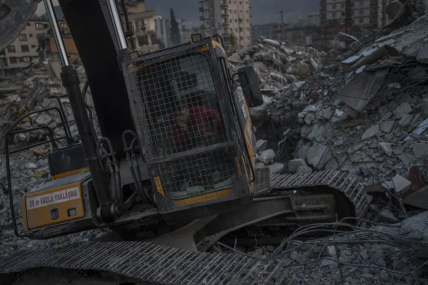 An excavator driver waits for a rescue team to recover the body of an earthquake victim from a collapsed building in Antakya, southeastern Turkey, Sunday, February 12, 2023. AP/RSS Photo