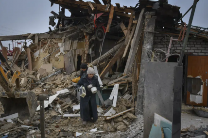 Local residents carry their belongings as they leave their home ruined in the Saturday Russian rocket attack in Zaporizhzhya, Ukraine, Sunday, Jan. 1, 2023. AP/RSS Photo