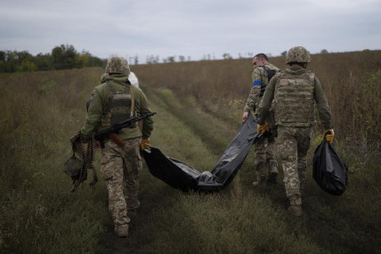 Ukrainian servicemen carry a bag containing the body of a Ukrainian soldier, center, as one of them, right, carries the remains of a body of a Russian soldier in a retaken area near the border with Russia in Kharkiv region, Ukraine, Saturday, Sept. 17, 2022.  AP/RSS Photo