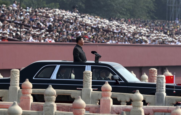 Chinese leader Xi Jinping rides in an open-top limousine during a parade to mark the 70th anniversary of the founding of Communist China in Beijing, Tuesday, Oct. 1, 2019.