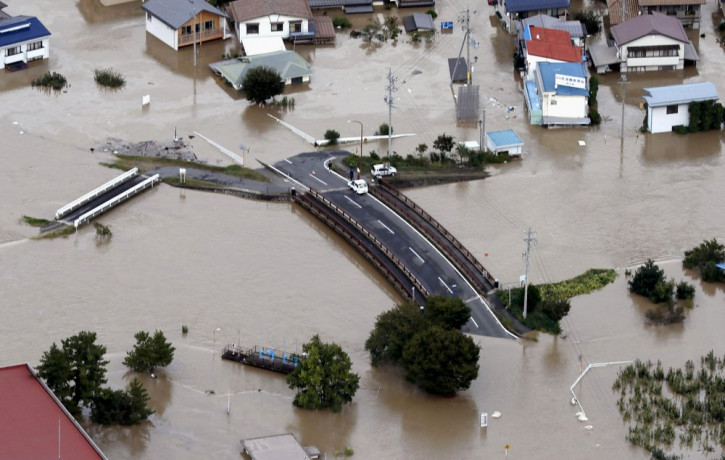 Cars are stranded on a road as the city is submerged in muddy waters after an embankment of the Chikuma River broke, in Nagano, central Japan, Sunday, Oct. 13, 2019.