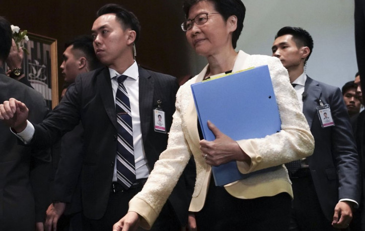 In this Oct. 17, 2019, file photo, Hong Kong Chief Executive Carrie Lam, center, arrives at chamber of the Legislative Council in Hong Kong.