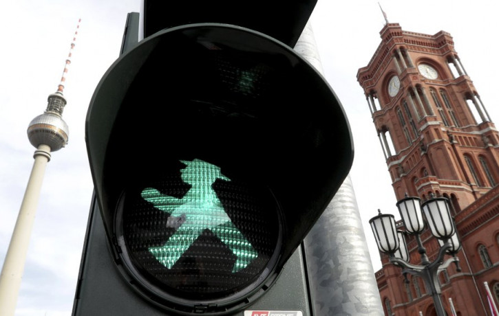 In this Tuesday, Oct. 22, 2019 photo a little traffic-light man is pictured in front of the Berlin TV Tower, left, and the 'Rotes Rathaus' (red townhall), right, in Berlin, Germany.